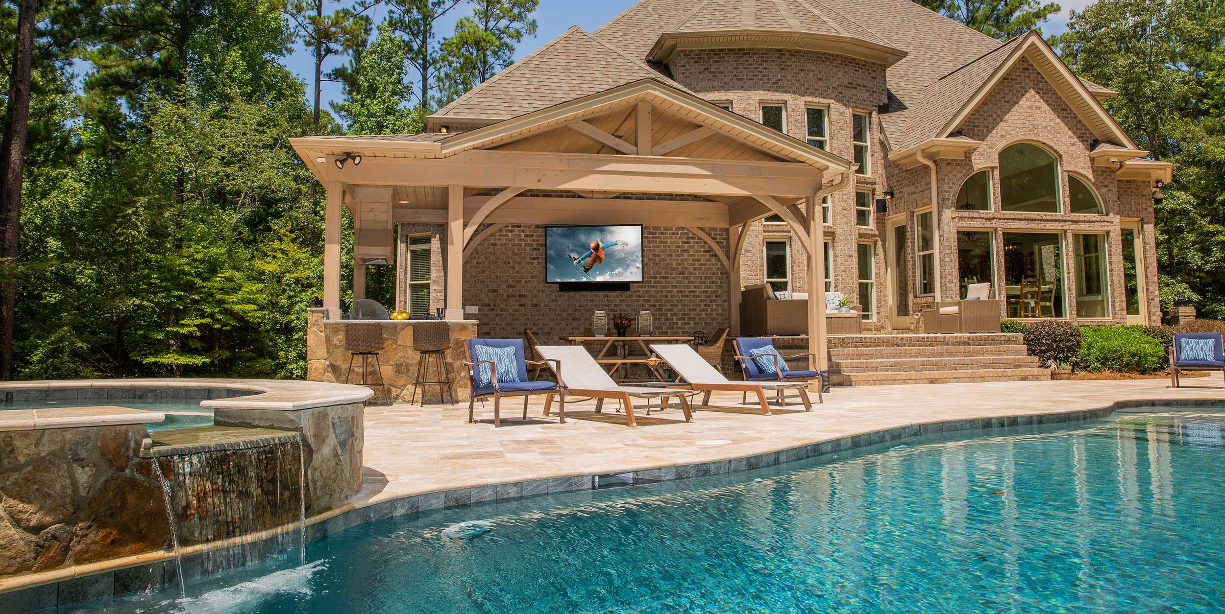 outdoor pool in a yard with seating and greenery